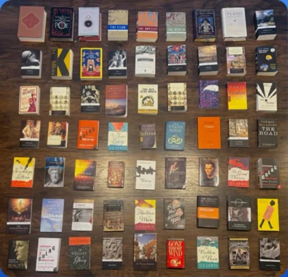 Rows of paperbacks laid out face up on a dark wooden table, photographed from above.